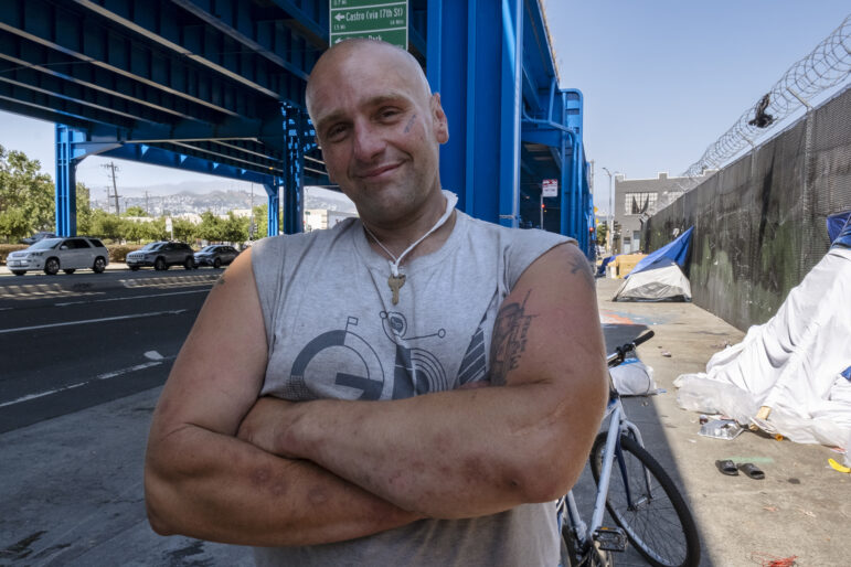 Vinny Vizgaudis smiles under a freeway overpass.