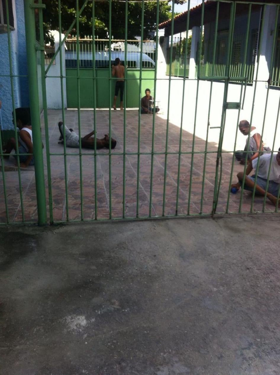 A group of persons with disabilities in a yard in an institution in Rio de Janeiro. Residents are taken outside for a few hours during the day but spend most of the time confined to their beds.