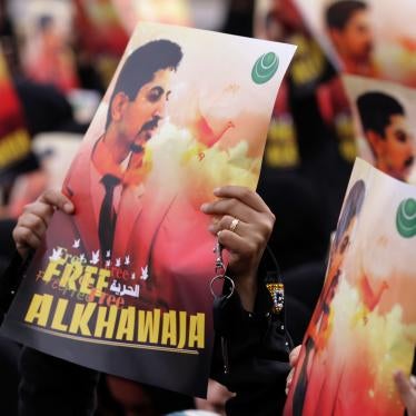 Bahraini anti-government protesters raise signs with images of jailed human rights activist Abdulhadi al-Khawaja Friday, April 6, 2012, in Jidhafs, Bahrain.