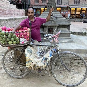 A man poses for a photo with his fruit cart