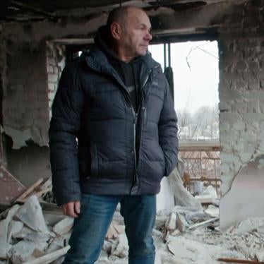 Mykhailo Yatsentiuk in the ruins of the building at 2 Pershotravneva Street in Izium, his former home, in December 2022
