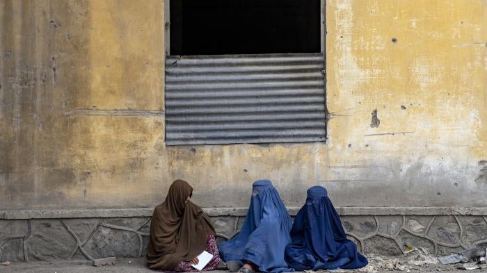 Afghan women wait to receive food rations distributed by a humanitarian aid group, Kabul, Afghanistan, May 23, 2023. 