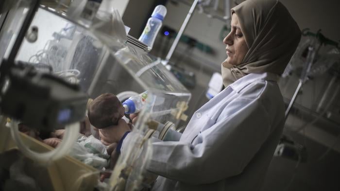 A Palestinian doctor in a hospital in Rafah in the southern Gaza Strip prepares a premature baby to be transferred to Egypt to receive proper medical care, November 20, 2023. 