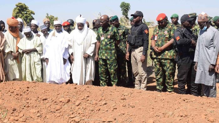 Nigerian Chief of Army Staff Lt. Gen. Taoreed Lagbaja, center, with other community leaders at the grave side where victims of an army drone attack were buried in Tudun Biri village, Nigeria, December 5, 2023.