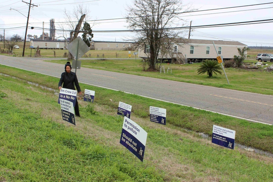 A woman places signs next to a levee