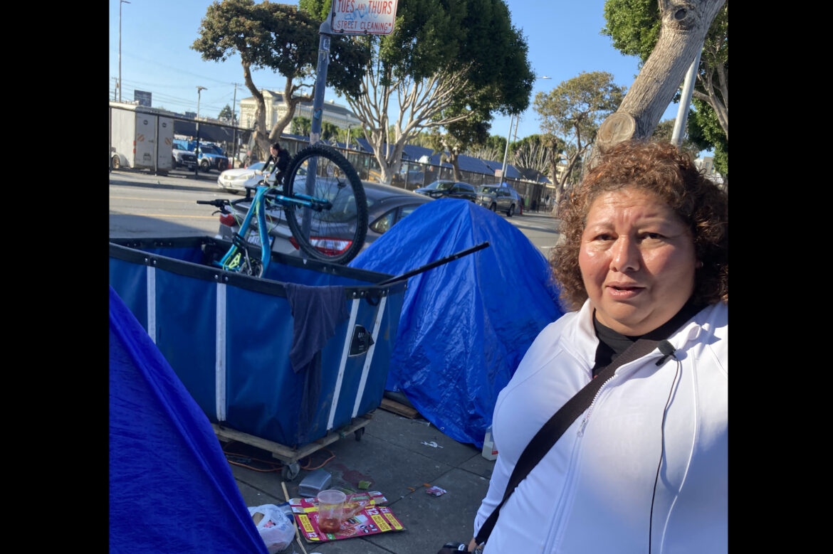 Aurelia Ramirez walks by tents and debris along Folsom Street.