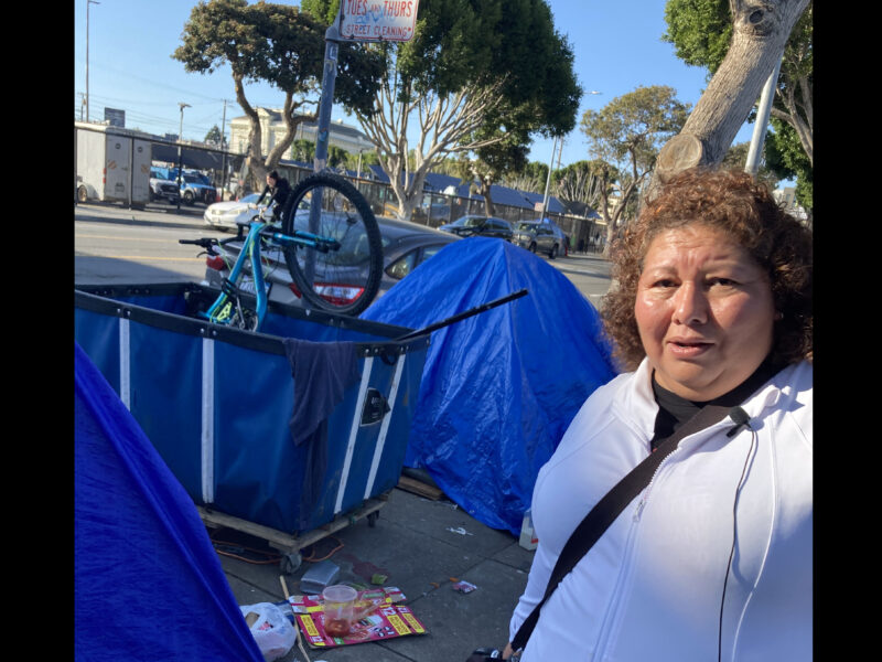 Aurelia Ramirez walks by tents and debris along Folsom Street.