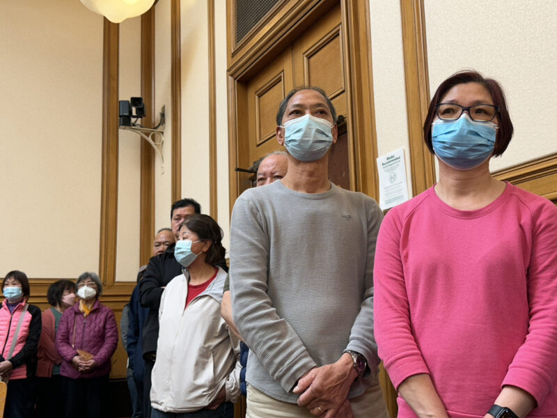 People standing in line at a public meeting at San Francisco City Hall.