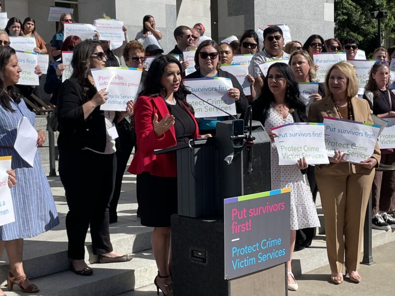 Many people gather behind Sen. Susan Rubio, who is speaking at a podium at the state Capitol.