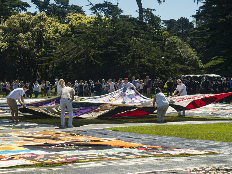 Volunteers spread open a panel of the AIDS Memorial Quilt during an opening ceremony on Saturday, June 11, 2022, at Robin Williams Meadow in Golden Gate Park. This was the largest display of the quilt since it was shown in Washington, D.C., in 2012.