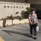 A woman walks out of the Chinatown Public Health Center.