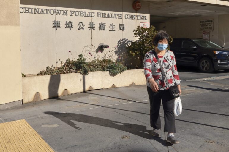 A woman walks out of the Chinatown Public Health Center.