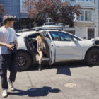 Passengers disembark a Waymo vehicle.