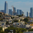 Homes in San Francisco's Bayview-Hunters Point neighborhood are seen against a background of skyscrapers in the city's financial district.