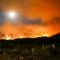 A wildfire rages in the distance, in California's Sierra Nevada mountains.