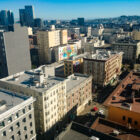 A birds-eye view of several multi-story apartment buildings, with downtown San Francisco in the background.