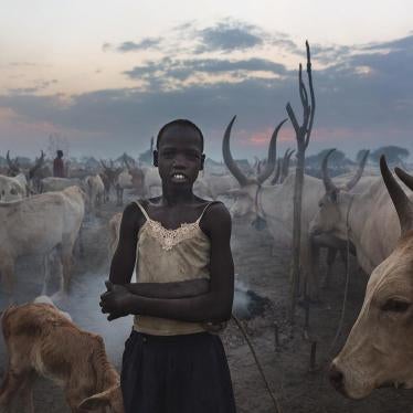 A young, unmarried girl stands amid a herd of cattle outside Bor, the capital of Jonglei State.  Cattle carry significant social, economic, and cultural importance for South Sudan's pastoralist ethnic groups, which use cows for payment of dowry.